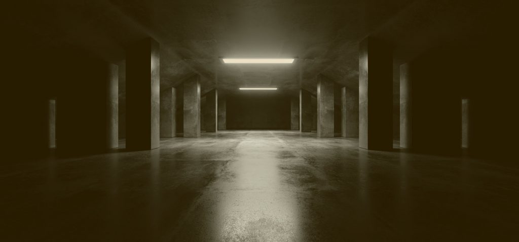 Bild einer betonierten niedrigen Halle in dunklem Grau mit Beleuchtung. Startbild der Website von Global Trockenbau